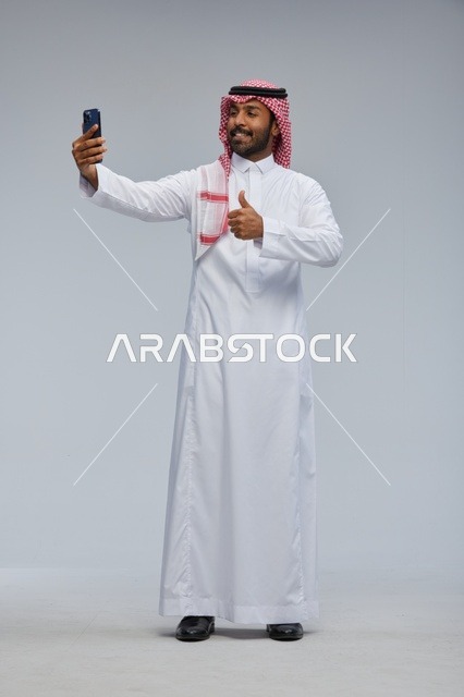 Saudi Man in Traditional Thobe Taking Selfie
