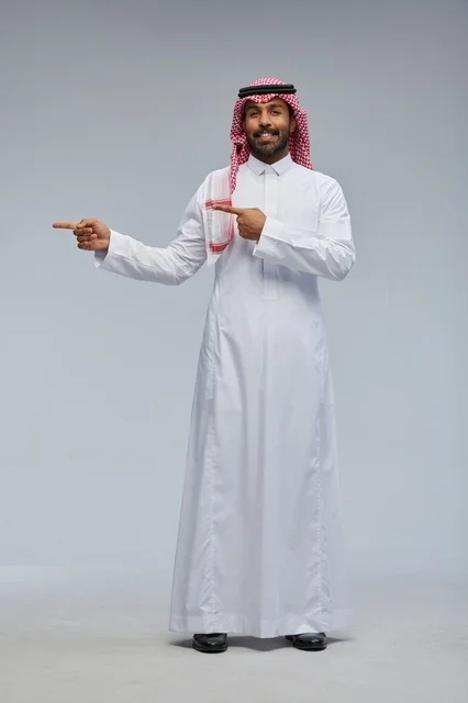 رجل سعودي بالزي التقليدي يشير إلى الجانب