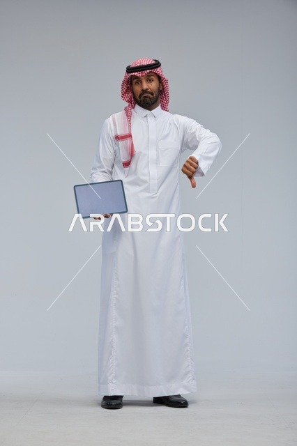 Saudi Man with Tablet Giving Thumbs Down Gesture