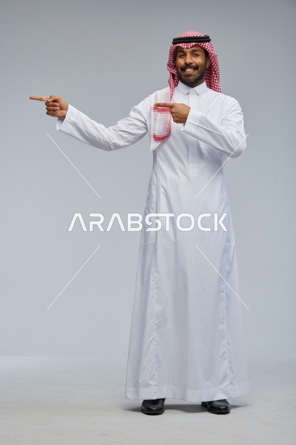 Saudi Man in Traditional Thobe Pointing in Studio Portrait