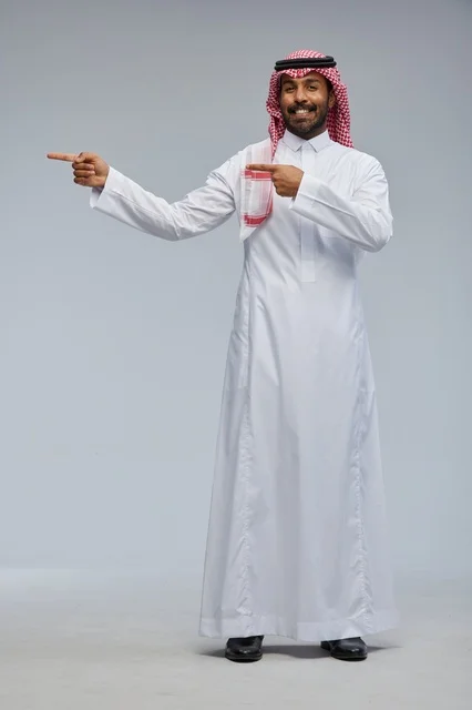 رجل سعودي بالزي التقليدي يشير بيده في لقطة استوديو