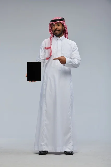 Saudi Man in Traditional Thobe Pointing at Tablet