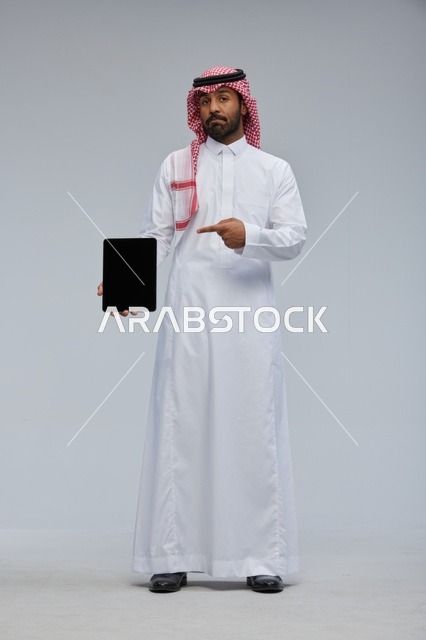 رجل سعودي يشير إلى جهاز لوحي في الاستوديو