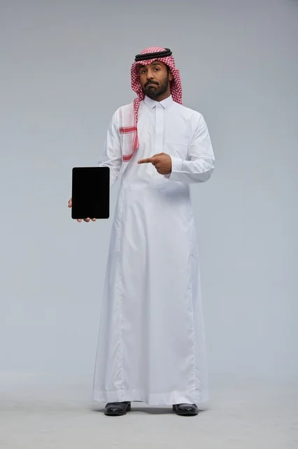 رجل سعودي يشير إلى جهاز لوحي في الاستوديو