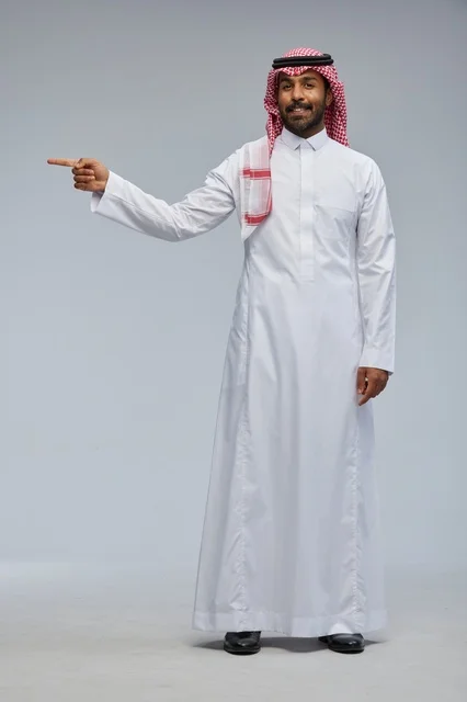 Smiling Saudi Man in Traditional Dress Pointing to Side