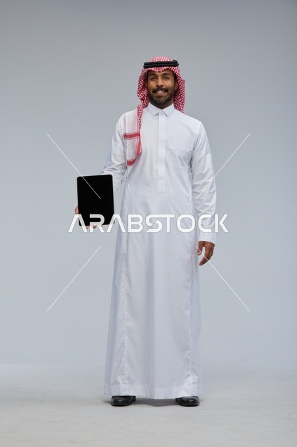 Saudi Man Holding Blank Tablet on Grey Background