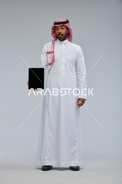 Saudi Man Holding Digital Tablet with Surprised Expression