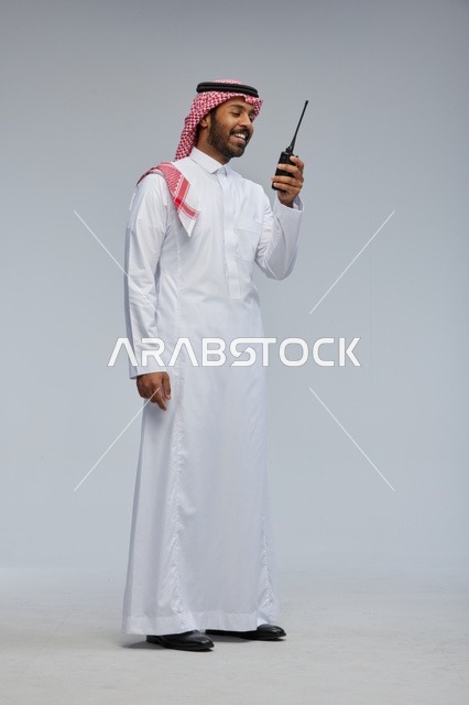 Saudi Man Using Walkie-Talkie in Traditional Thobe