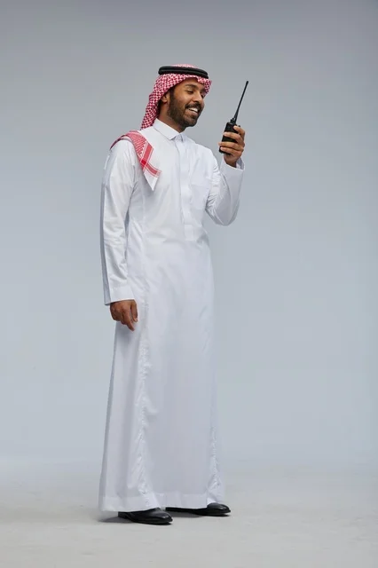 Saudi Man Using Walkie-Talkie in Traditional Thobe