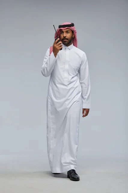 Saudi Man Using Walkie-Talkie in Traditional Thobe