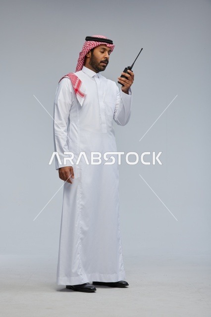 Saudi Man Using Walkie Talkie in Studio Setting