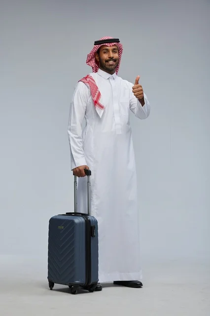 Saudi man traveling with suitcase in traditional attire