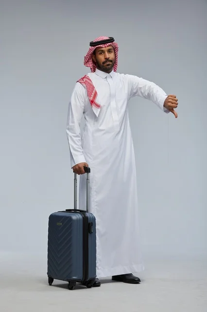 Saudi Man with Suitcase Making Thumbs Down Gesture