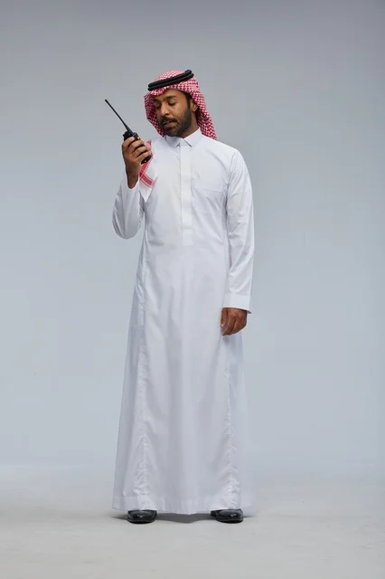 Saudi Man Using Walkie-Talkie in Traditional Thobe
