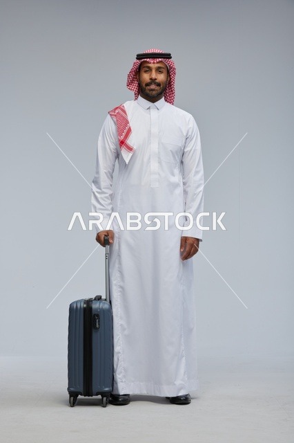 رجل سعودي مسافر مع حقيبة بالزي التقليدي