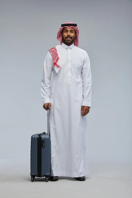 رجل سعودي مسافر مع حقيبة بالزي التقليدي