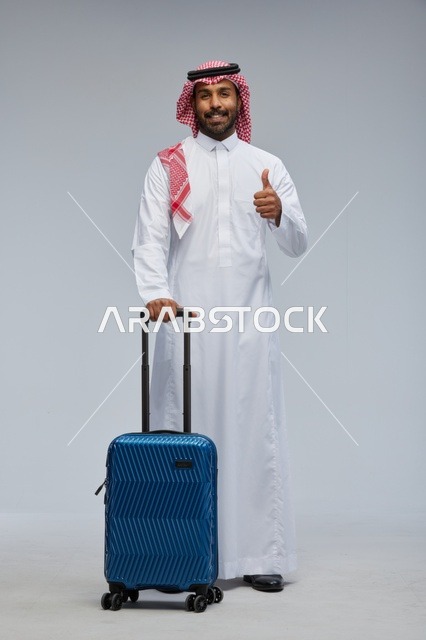 رجل سعودي مسافر مع حقيبة بالزي التقليدي