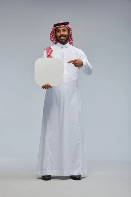 رجل سعودي مبتسم يحمل لوحة فارغة