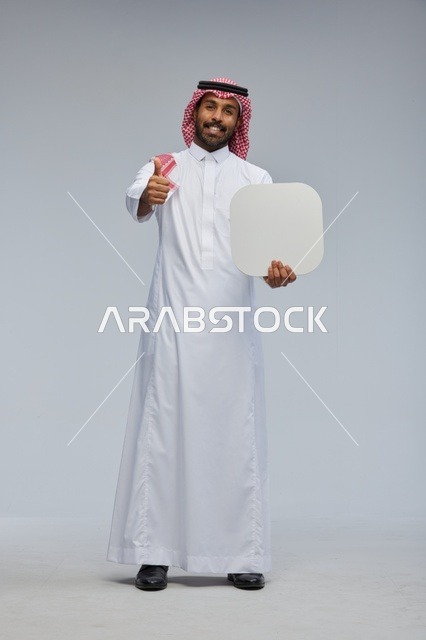 رجل سعودي مبتسم يحمل لوحة فارغة