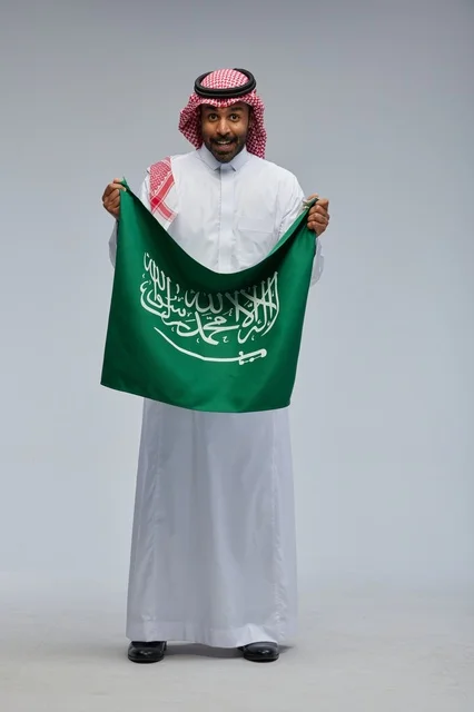 رجل سعودي يحمل علم المملكة العربية السعودية