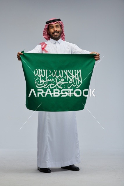 Saudi Man Holding National Flag on Grey Background