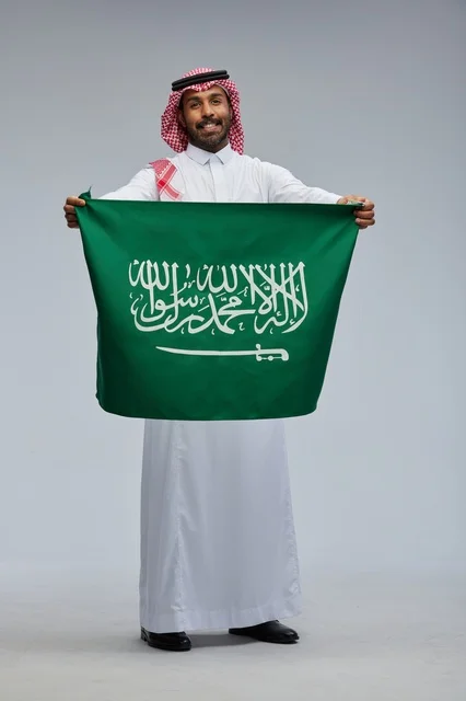رجل سعودي يحمل علم المملكة العربية السعودية