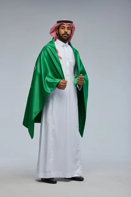 رجل سعودي يرتدي علم المملكة العربية السعودية