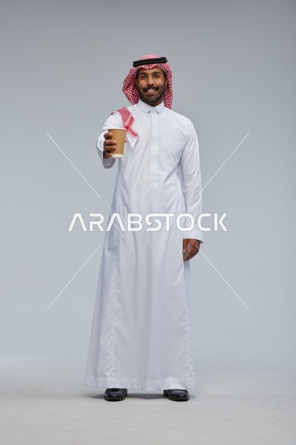 رجل سعودي يقدم كوب قهوة في استوديو