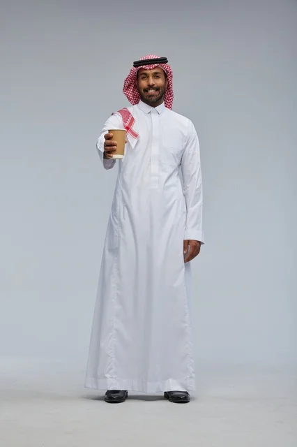 رجل سعودي يقدم كوب قهوة في استوديو