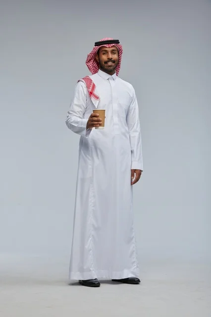 رجل سعودي بالثوب التقليدي يحمل كوب قهوة