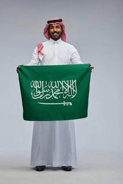 رجل سعودي يحمل علم المملكة العربية السعودية