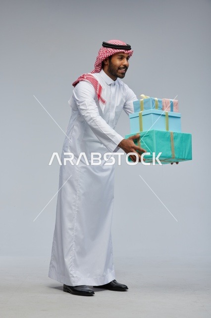 Saudi Man Holding Stack of Gift Boxes in Studio