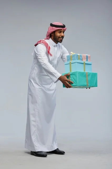 Saudi Man Holding Gift Boxes on Gray Background