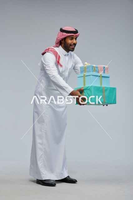 Saudi Man Holding Stack of Gift Boxes in Studio