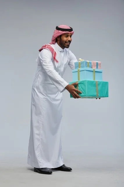رجل سعودي يحمل صناديق هدايا في الاستوديو