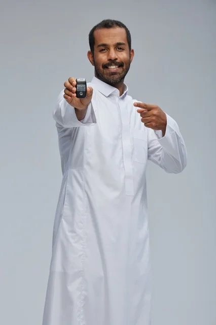 رجل سعودي يحمل مفتاح سيارة في الاستوديو