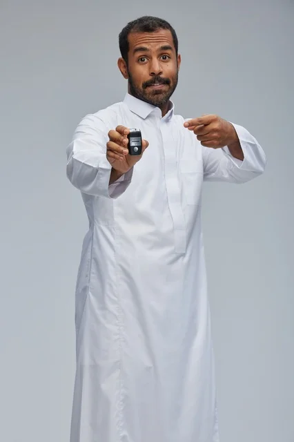 Saudi Man Holding Electronic Car Key in Traditional Thobe