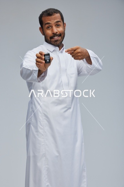رجل سعودي بالثوب التقليدي يمسك مفتاح سيارة