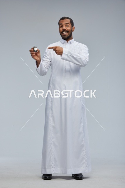رجل سعودي يحمل مفتاح سيارة بالثوب الأبيض