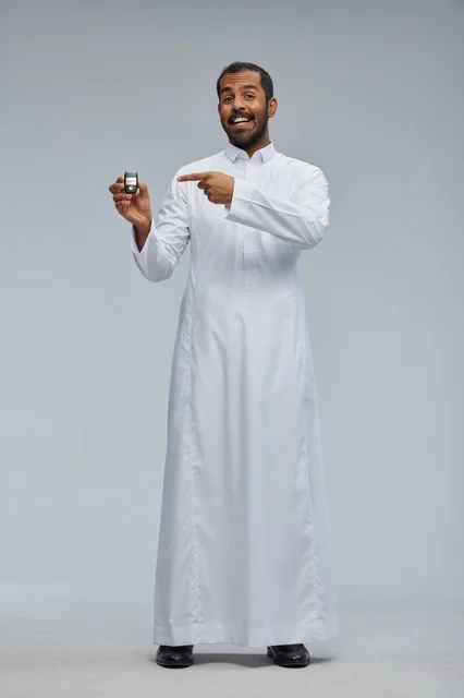 رجل سعودي يحمل مفتاح سيارة بالثوب الأبيض