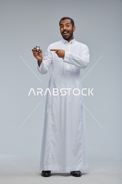 رجل سعودي يحمل مفتاح سيارة في استوديو