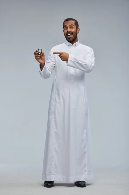 رجل سعودي يحمل مفتاح سيارة في استوديو