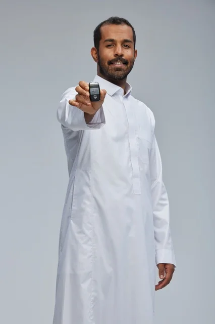 رجل سعودي يحمل مفتاح سيارة في الاستوديو