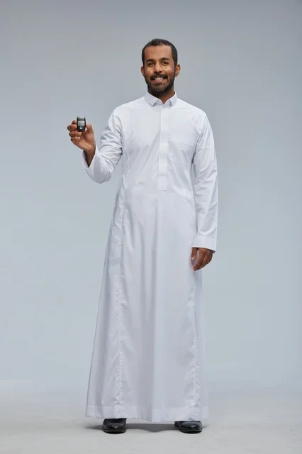 رجل سعودي بالثوب الأبيض يحمل مفتاح سيارة