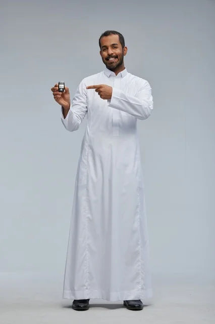 رجل سعودي يحمل مفتاح سيارة في استوديو