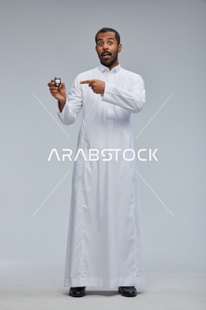رجل سعودي يحمل مفتاح سيارة بالثوب التقليدي