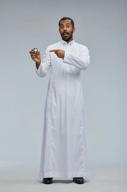 رجل سعودي يحمل مفتاح سيارة بالثوب التقليدي