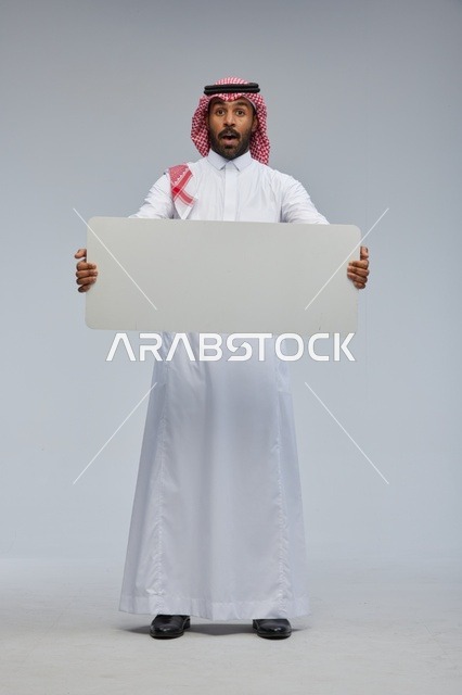 رجل سعودي مندهش يحمل لوحة بيضاء فارغة