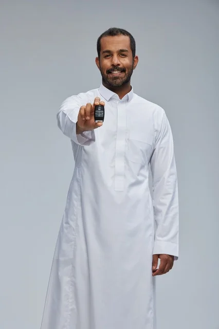 رجل سعودي يحمل مفتاح سيارة في الاستوديو