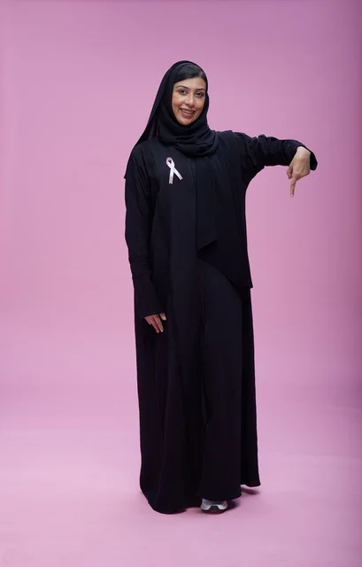 امرأة سعودية مع شريط التوعية بسرطان الثدي